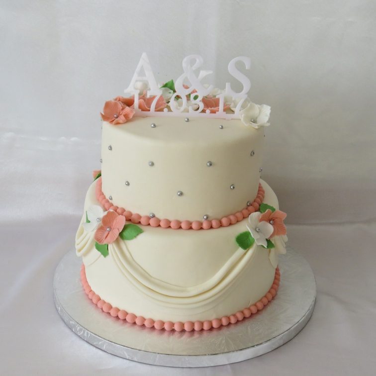 Ivory wedding cake with flowers and drapery